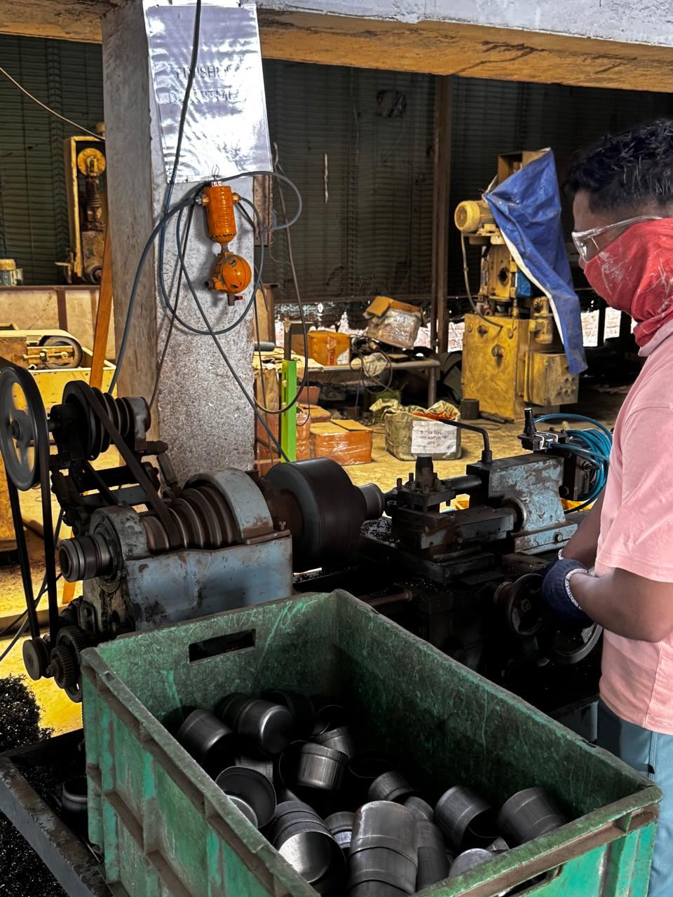 Operator turning SS end caps on a lathe at Ruby Infra