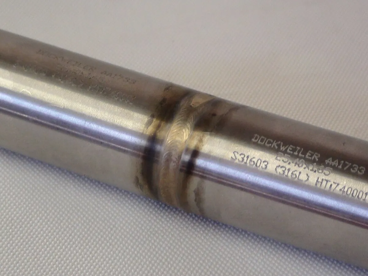 Close-up of a welded stainless steel tube showing the weld bead